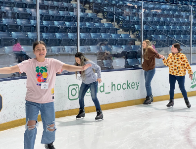 Students ice skating in Compton Family Ice Arena
