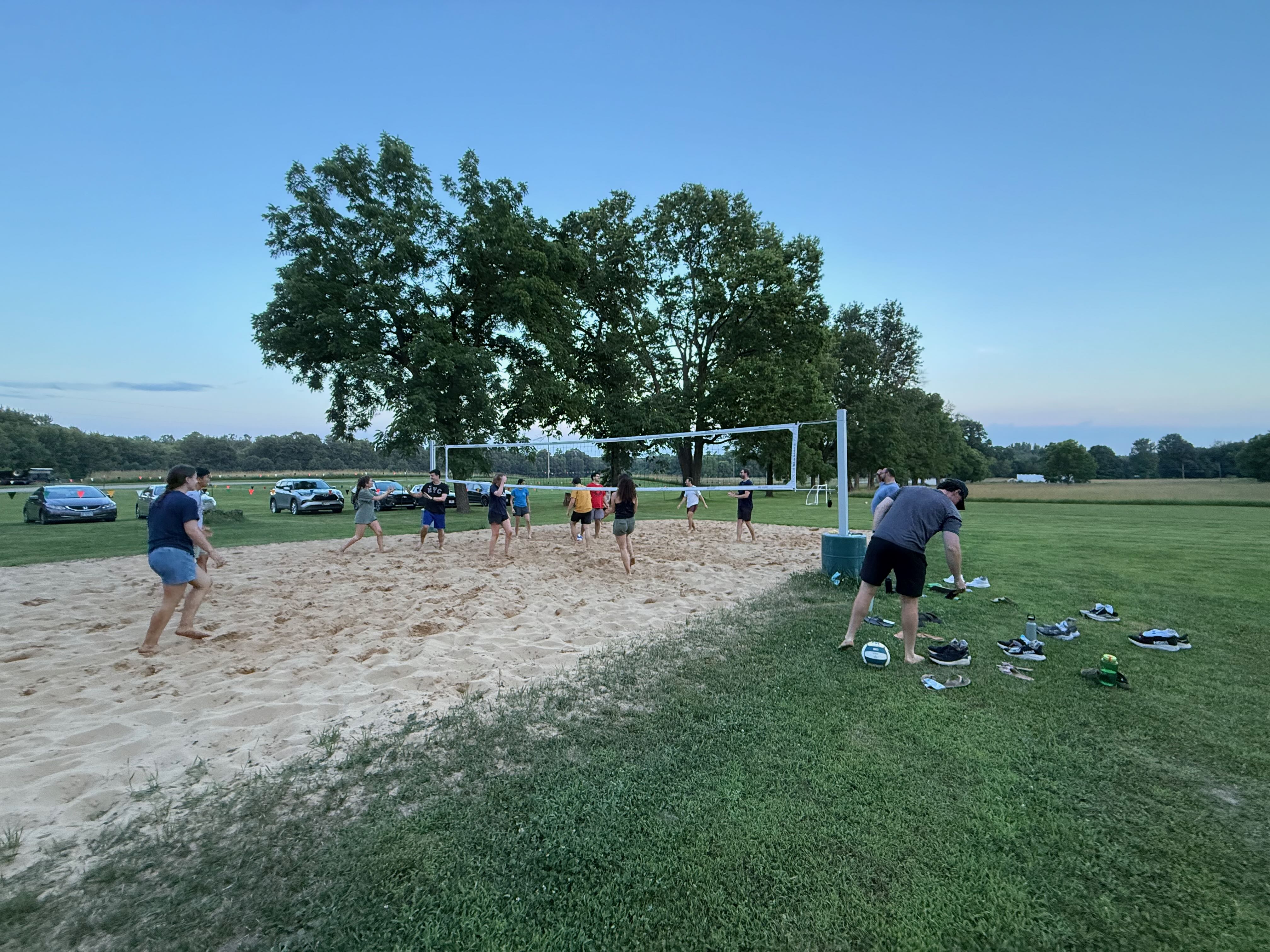 Image of the sand volleyball court filled with ACE teachers playing volleyball at Ronora Lodge in Watervliet, Michigan