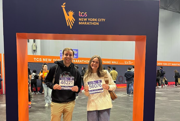 Jack Hutter (left) and Kate Chiappetta (right) holding up their bibs for the NYC Marathon 2025