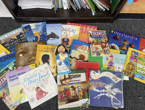 Plush Mary laying down with books in Schroeder's classroom. 