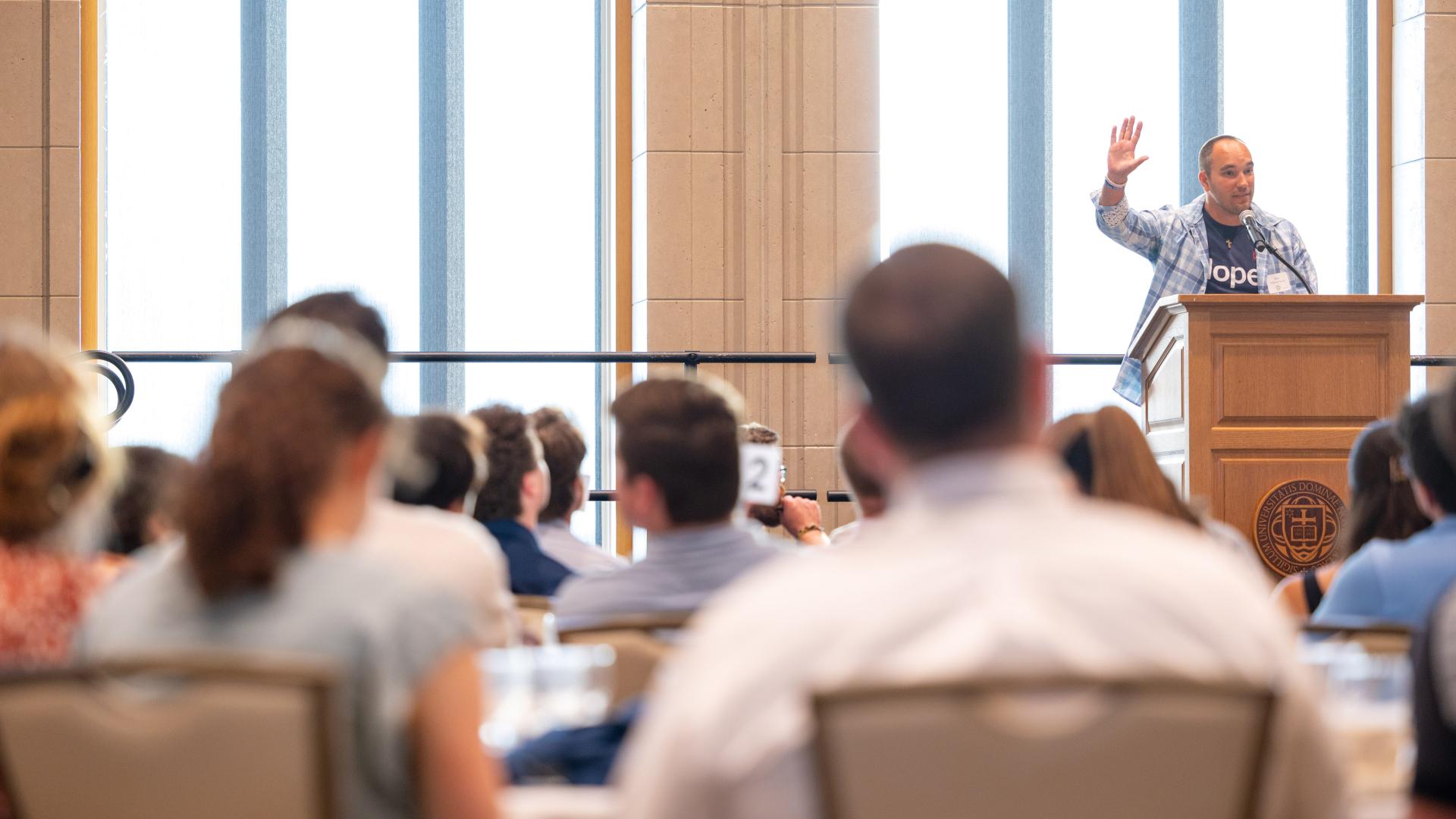 Annunciation Catholic School Principal Matt DeBoer speaks to audience in sun-filled room on campus at the University of Notre Dame